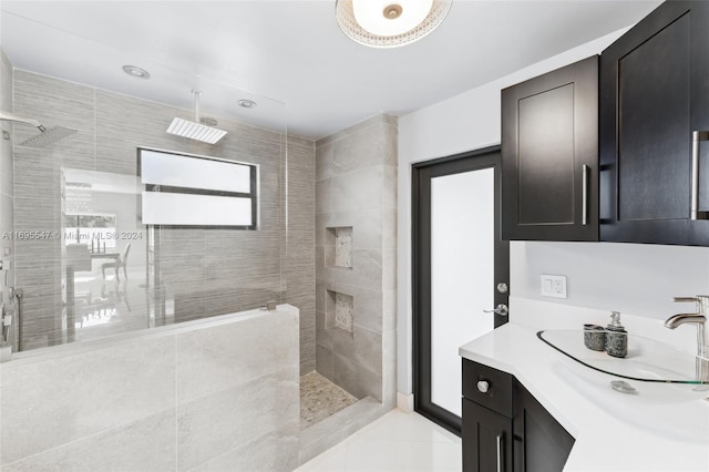 bathroom featuring tiled shower, vanity, and tile patterned floors