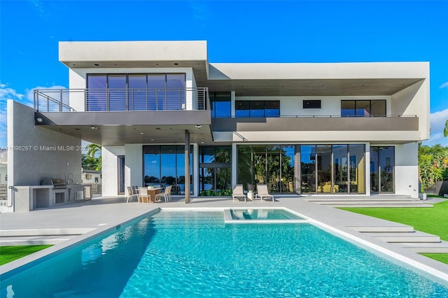 rear view of house with area for grilling, a balcony, and a patio