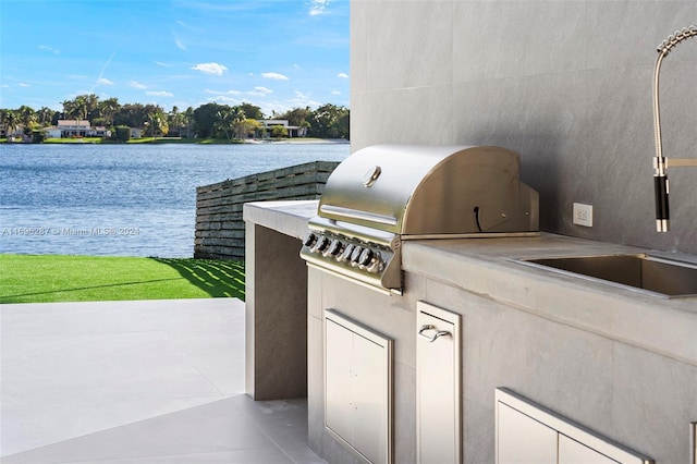 view of patio / terrace with area for grilling, a water view, and grilling area