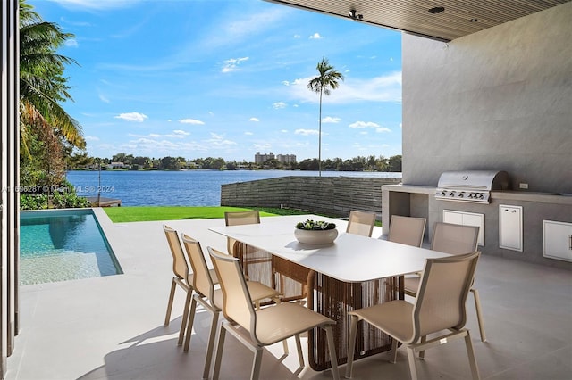 view of patio / terrace with an outdoor kitchen, a water view, and grilling area