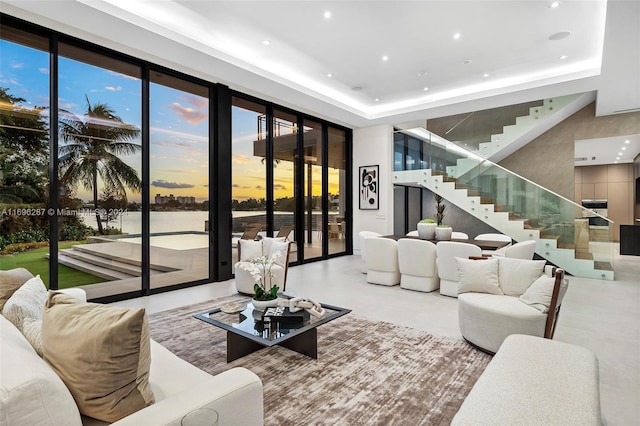 living room with a water view and a tray ceiling