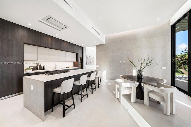 kitchen with dark brown cabinetry, a breakfast bar, a kitchen island, and plenty of natural light