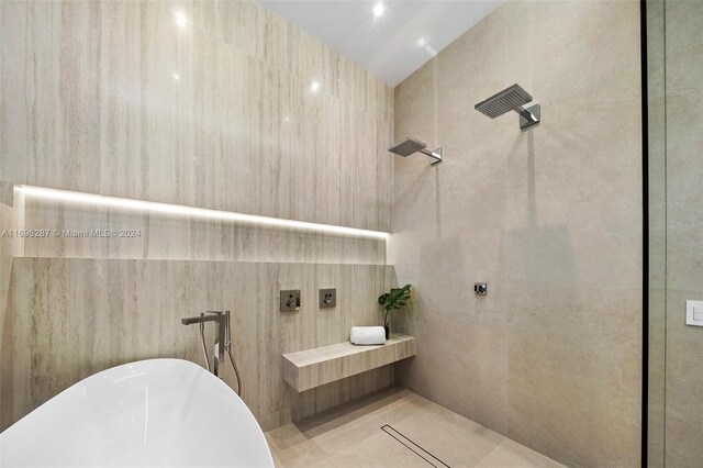 bathroom with tile patterned flooring, tile walls, and independent shower and bath