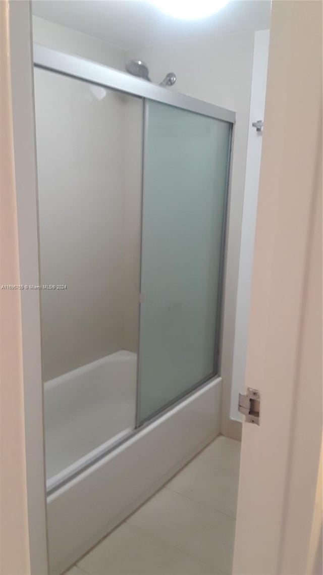 bathroom with tile patterned floors and combined bath / shower with glass door