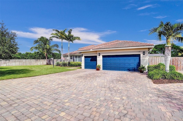 mediterranean / spanish-style home featuring a front yard and a garage