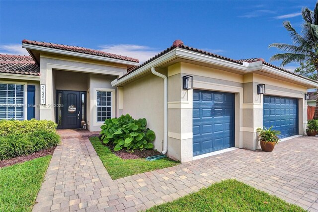 mediterranean / spanish-style house with a garage and a front lawn