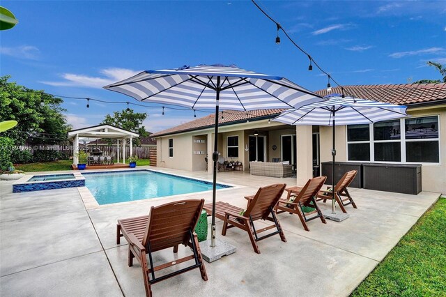 view of swimming pool featuring a patio area and an in ground hot tub