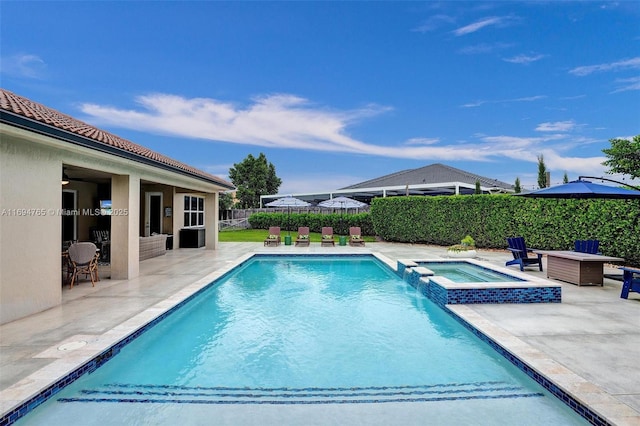 view of pool with a patio and an in ground hot tub