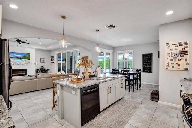 kitchen with white cabinets, ceiling fan, light stone countertops, black dishwasher, and decorative light fixtures