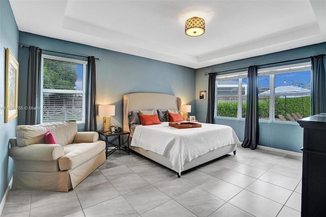 bedroom with multiple windows and a raised ceiling