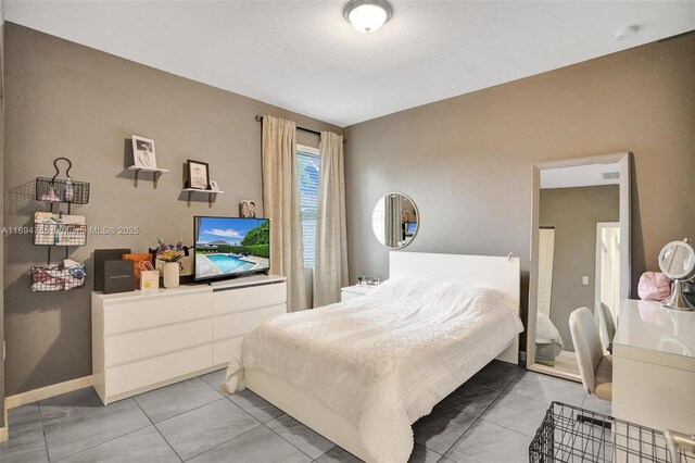 tiled bedroom with a textured ceiling