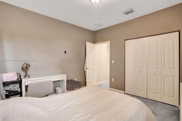 tiled bedroom with a textured ceiling and multiple windows