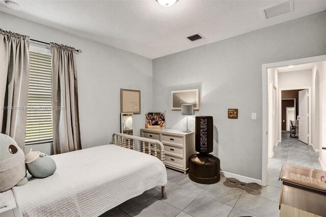 tiled bedroom with ensuite bathroom and a closet