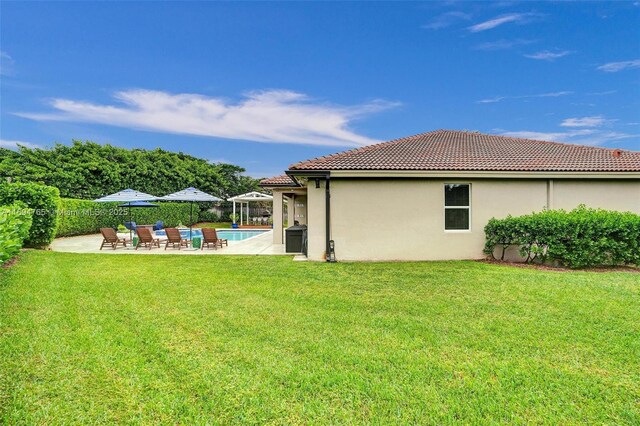 view of yard with a fenced in pool and a patio