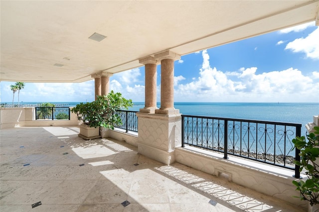 view of patio / terrace with a balcony and a water view