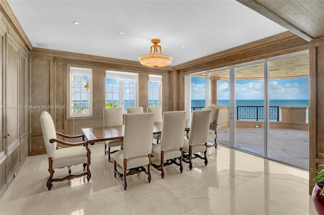 dining room featuring a water view and ornamental molding