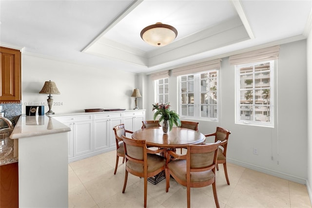 dining space with a raised ceiling and crown molding