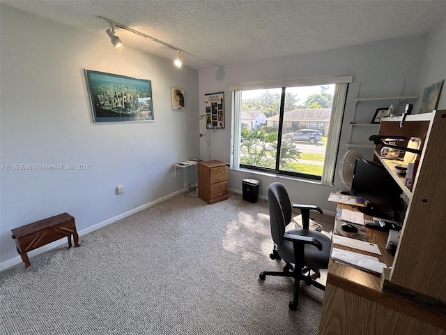 carpeted home office featuring a textured ceiling and track lighting