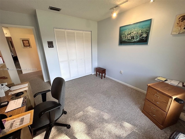 carpeted office space featuring a textured ceiling