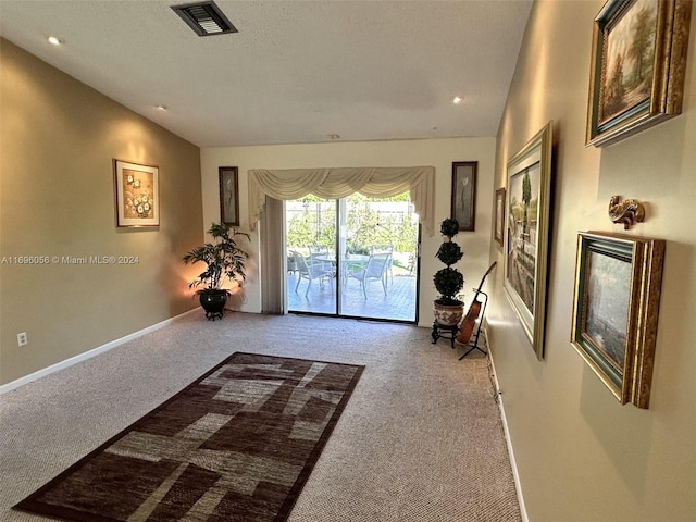 interior space with light carpet and vaulted ceiling