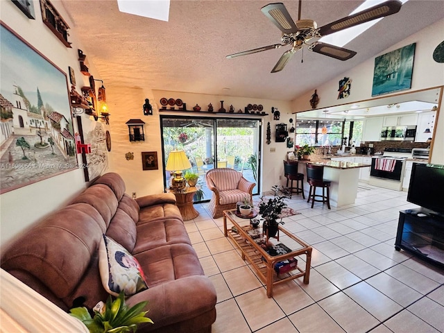 tiled living room with a textured ceiling, vaulted ceiling, and ceiling fan