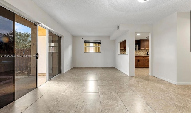 unfurnished room featuring light tile patterned floors and a textured ceiling