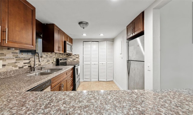 kitchen with decorative backsplash, sink, light tile patterned floors, and stainless steel appliances