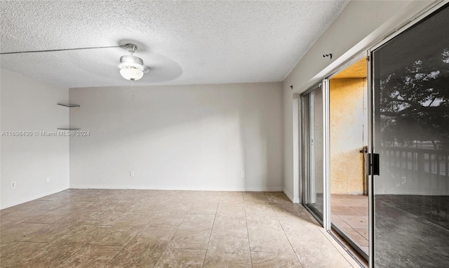 spare room with ceiling fan and a textured ceiling