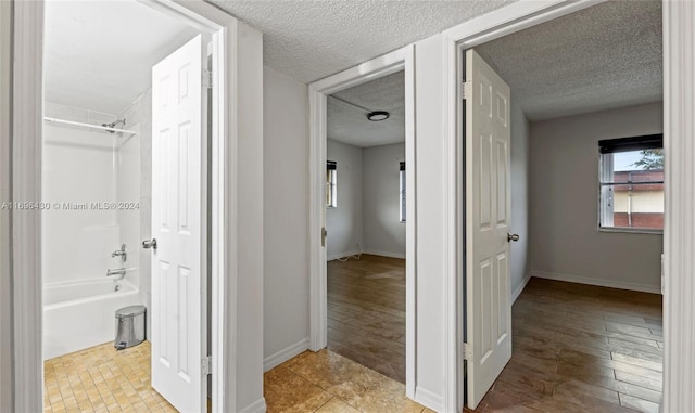 hall featuring a textured ceiling and light wood-type flooring