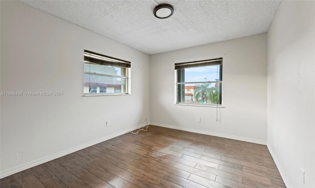 unfurnished room featuring hardwood / wood-style floors and a textured ceiling