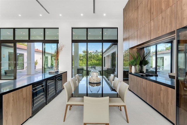 dining space featuring beverage cooler and a healthy amount of sunlight