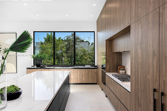 kitchen with light stone countertops and a wealth of natural light