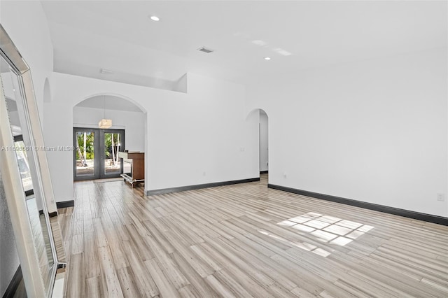 unfurnished room with light hardwood / wood-style floors and french doors