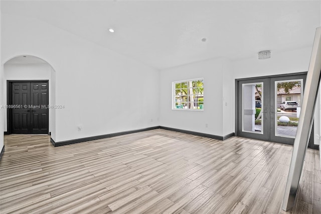 unfurnished room featuring french doors and light hardwood / wood-style flooring