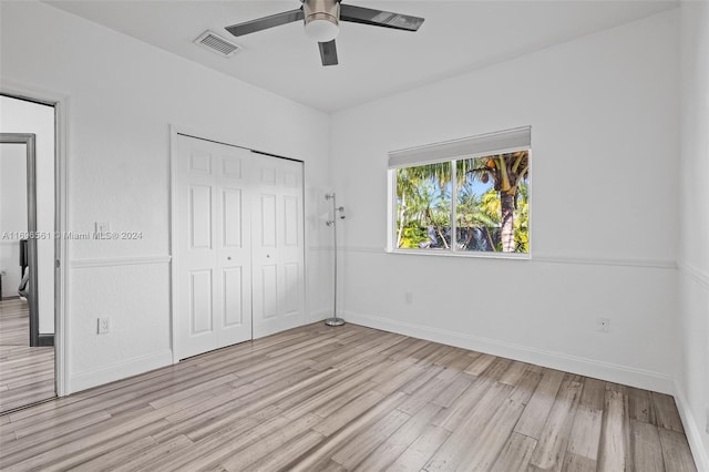 unfurnished bedroom featuring ceiling fan, light hardwood / wood-style flooring, and a closet