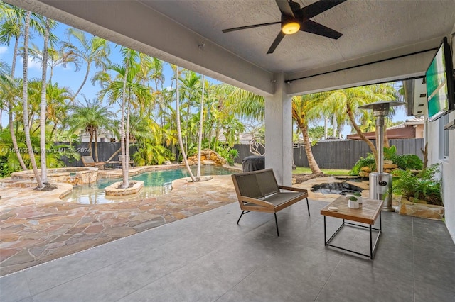 view of patio featuring ceiling fan and a pool with hot tub