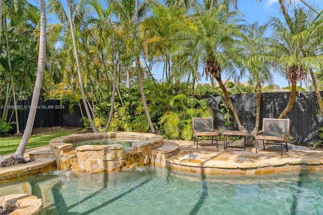 view of swimming pool with an in ground hot tub