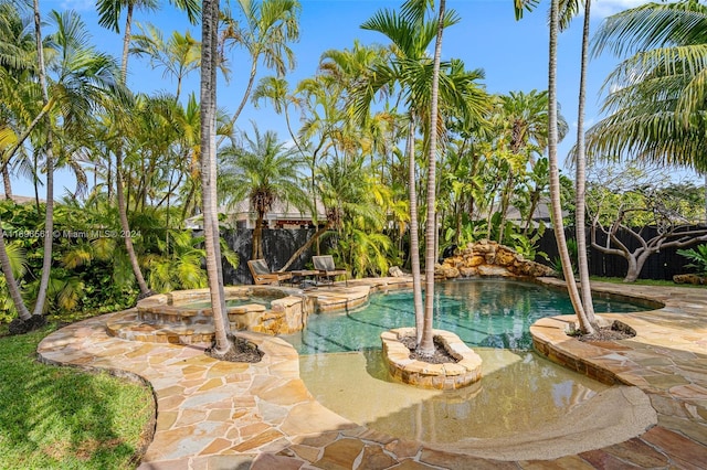 view of swimming pool with an in ground hot tub