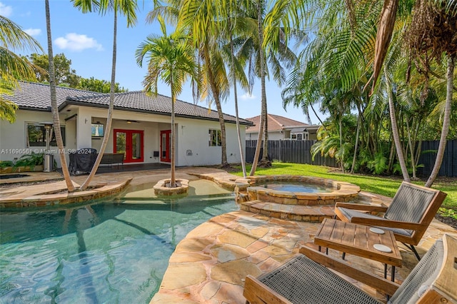 view of pool with an in ground hot tub, french doors, and a patio