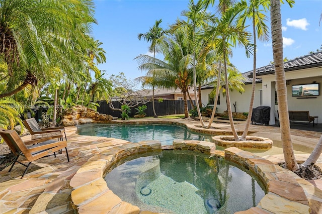 view of swimming pool with an in ground hot tub and a patio