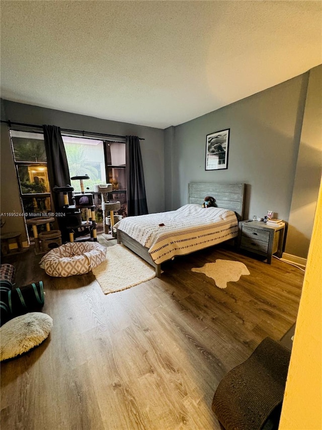 bedroom with hardwood / wood-style flooring and a textured ceiling