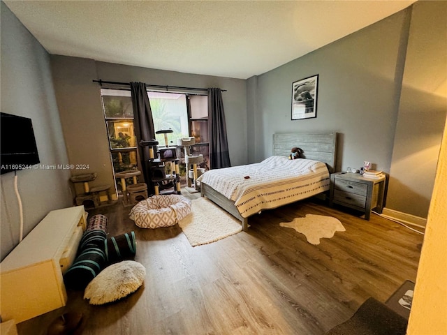 bedroom featuring wood-type flooring and a textured ceiling