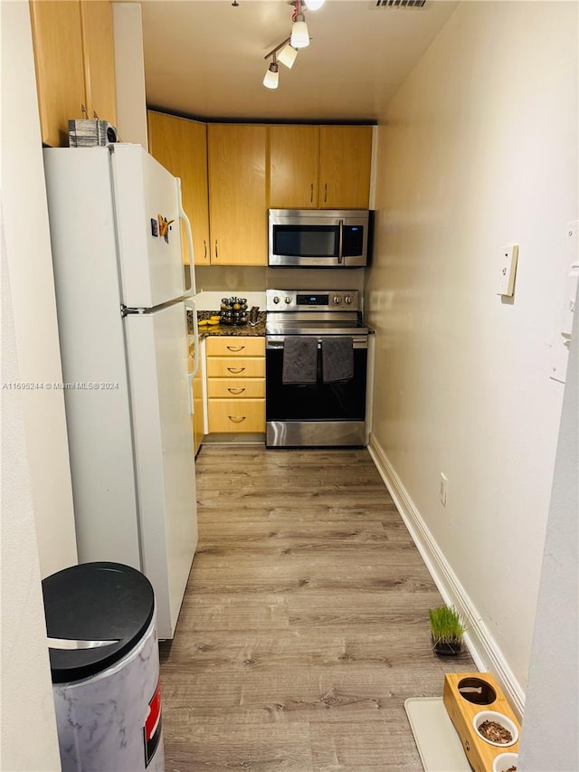 kitchen featuring light brown cabinets, rail lighting, light hardwood / wood-style floors, and appliances with stainless steel finishes