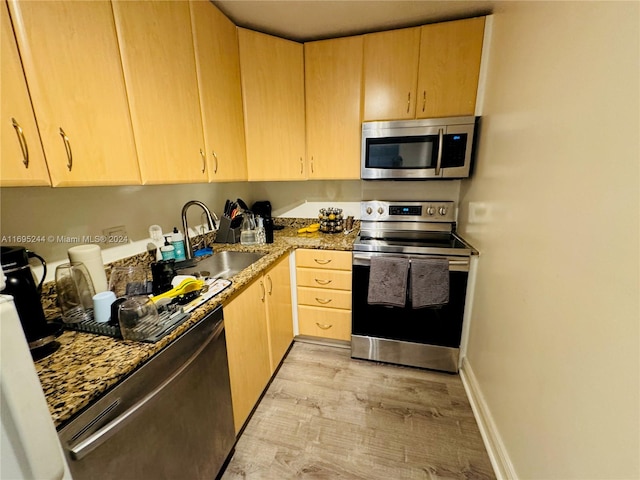 kitchen with sink, light hardwood / wood-style floors, light brown cabinets, and appliances with stainless steel finishes