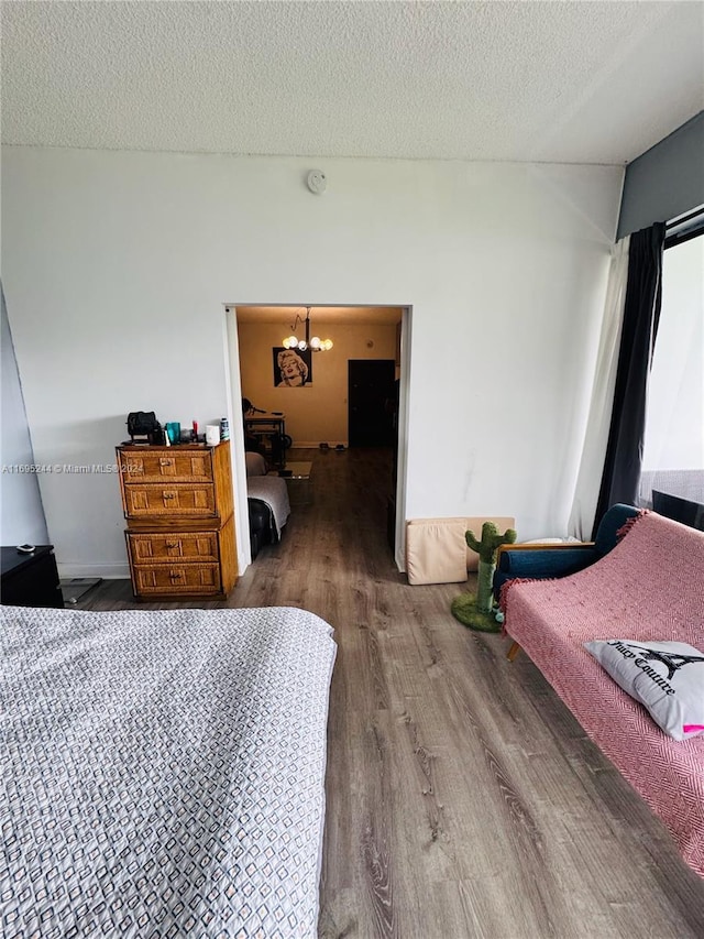 bedroom with a chandelier, wood-type flooring, and a textured ceiling