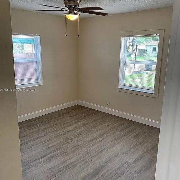 empty room featuring hardwood / wood-style floors, a healthy amount of sunlight, and a textured ceiling