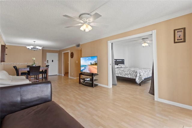 living room featuring light hardwood / wood-style floors, a textured ceiling, crown molding, and ceiling fan with notable chandelier