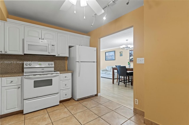 kitchen featuring white cabinetry, decorative backsplash, white appliances, track lighting, and ceiling fan with notable chandelier