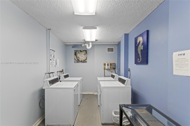 washroom featuring a textured ceiling, ceiling fan, and washer and dryer