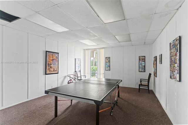 game room featuring carpet flooring and a drop ceiling